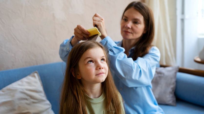 Madre quitando piojos a su hija